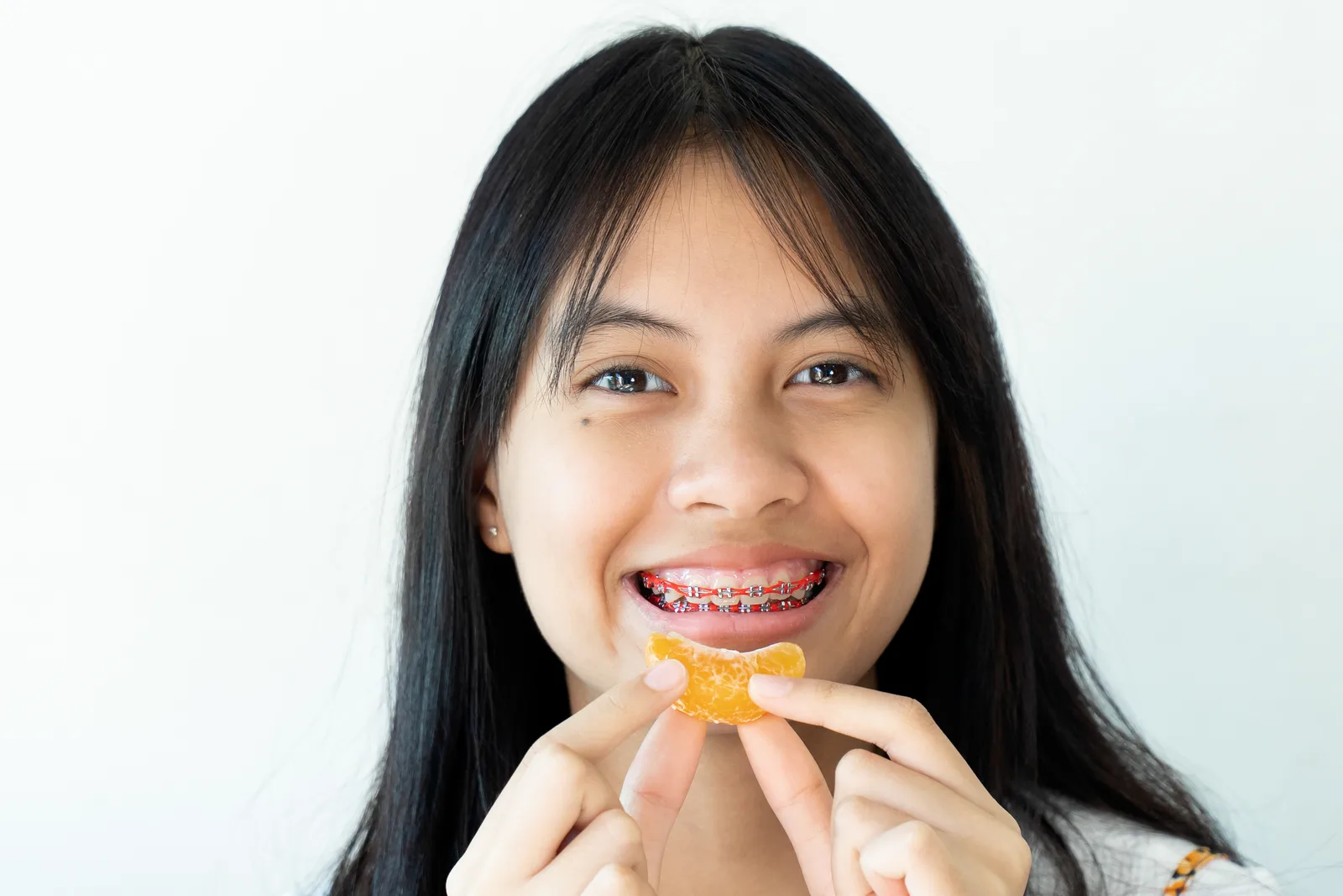 A girl with dental braces smiling.