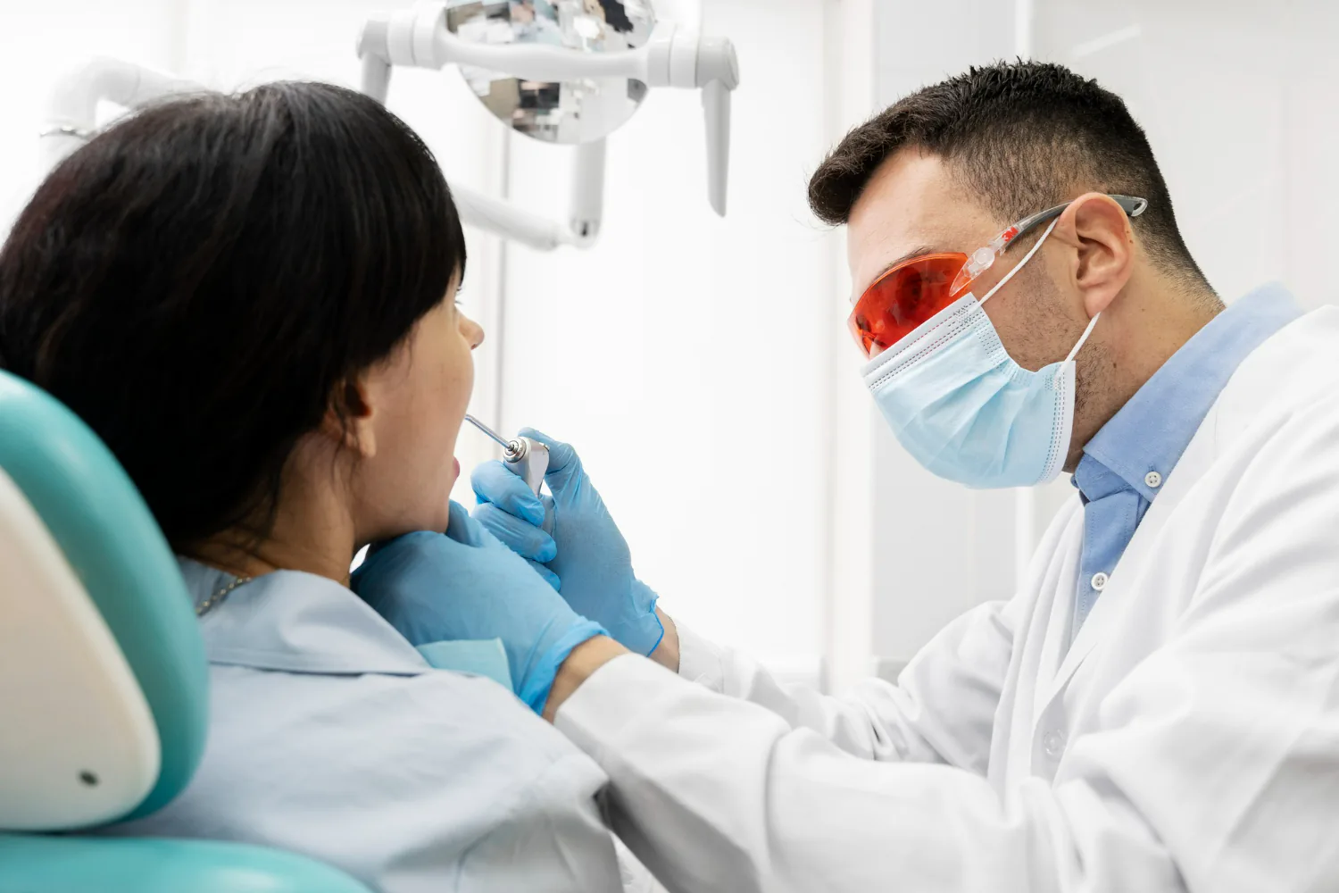 Dentist checking the patient’s teeth to ensure the veneer is fitted properly.