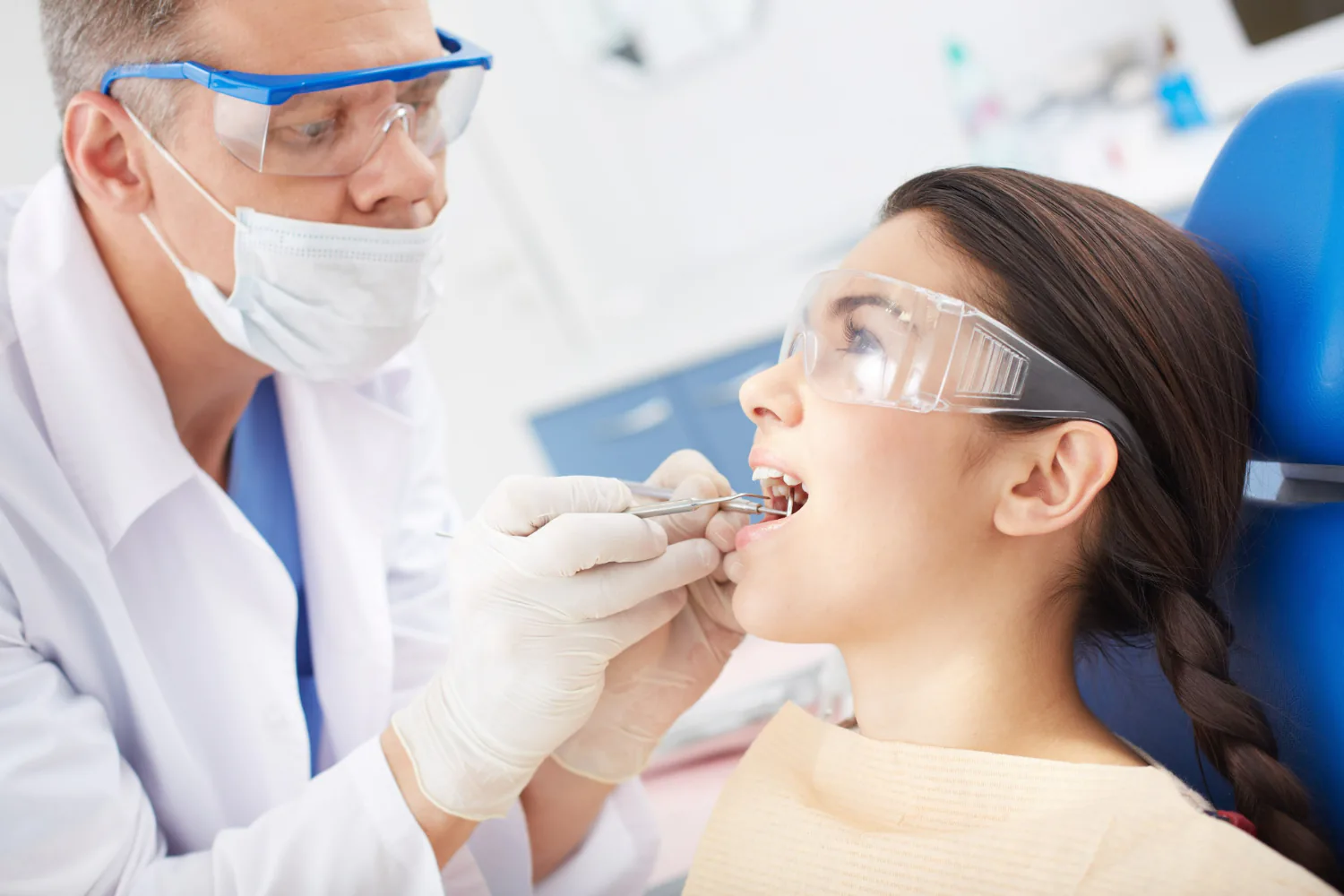 Dentist examining the patient’s teeth to monitor their progress.