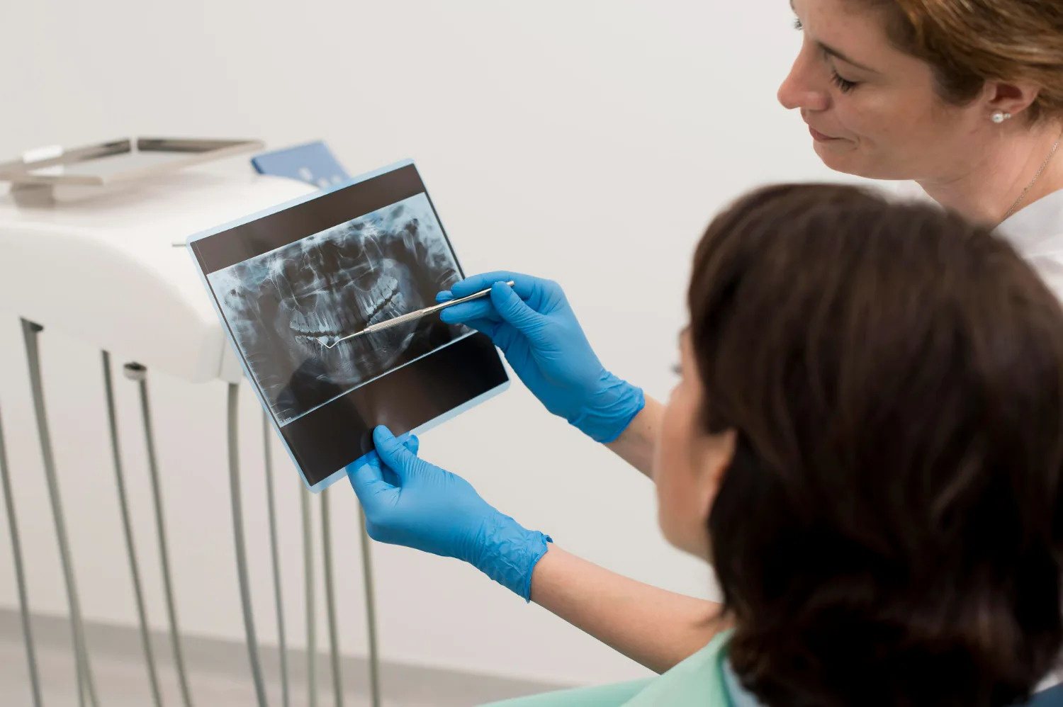 Dentist examining the patient’s teeth with an X-ray.