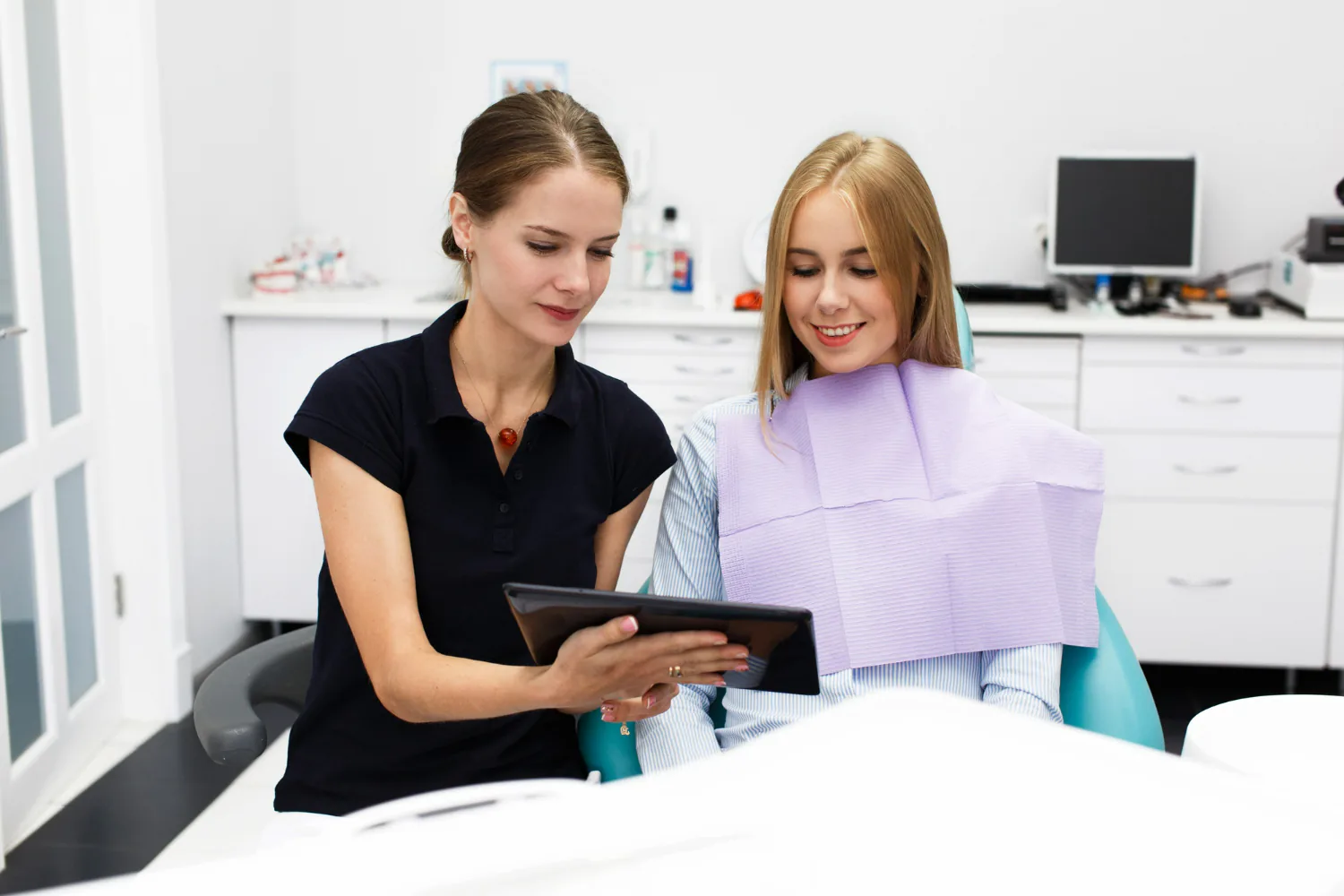 Dentist explaining to the patient on the preparations involved for veneer treatment.