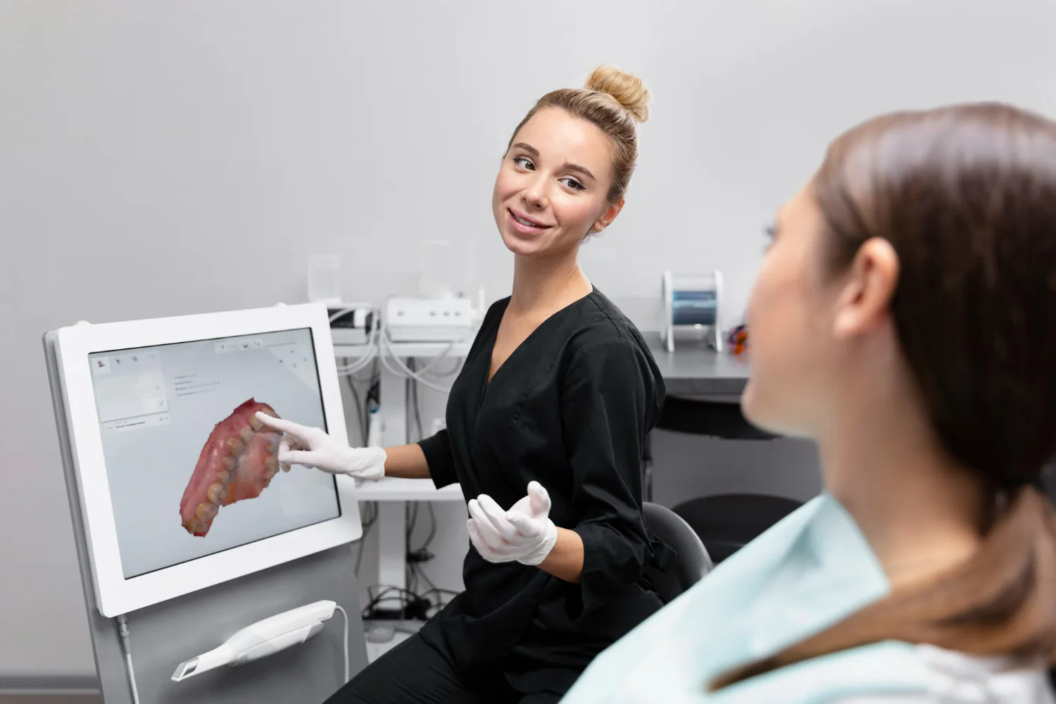 Dentist is showing the patient’s digital scan to make sure it fits their bite.