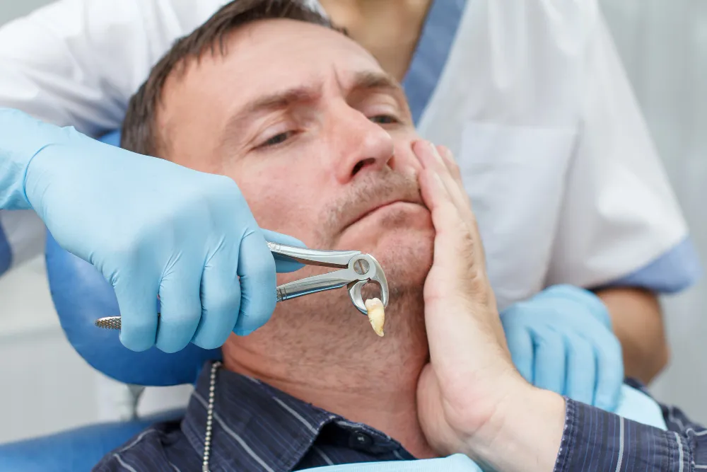 A dentist extracts a tooth from a patient.