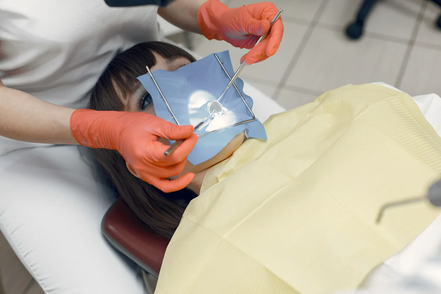 A temporary bridge is being fitted into the patient’s teeth to protect the gum area.
