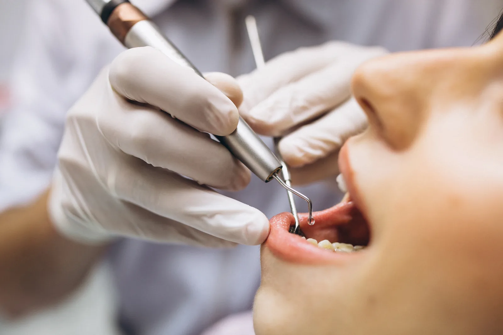 Dentist checking teeth and gums as part of a routine dental check-up.