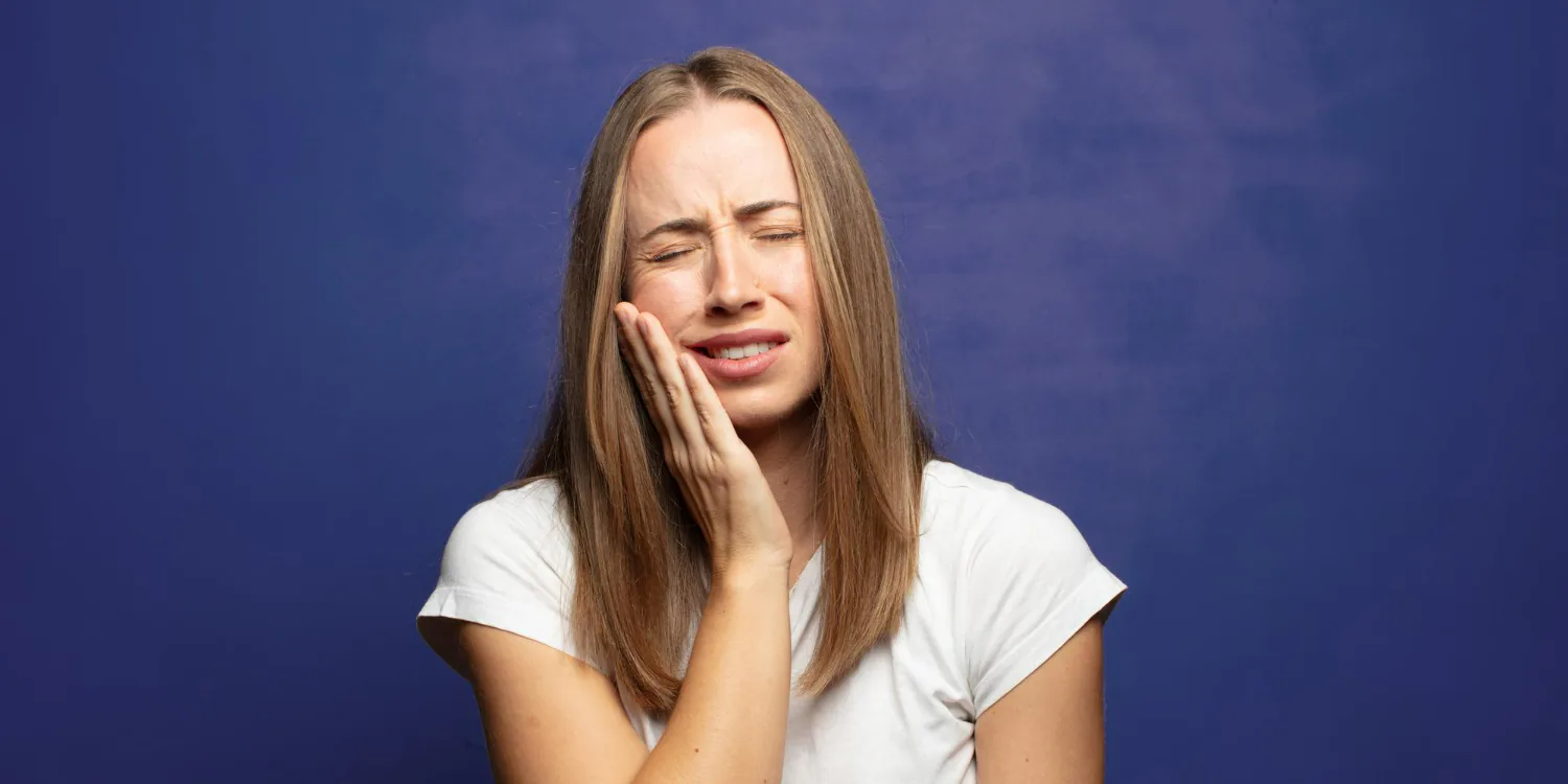 A woman suffering from wisdom tooth pain.